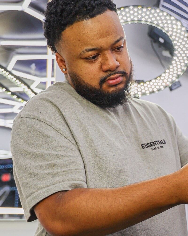 Eman cutting a client at Plugged N Empire