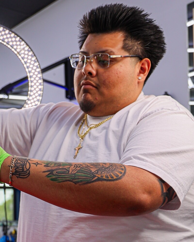 OKutz cutting a client at Plugged N Empire
