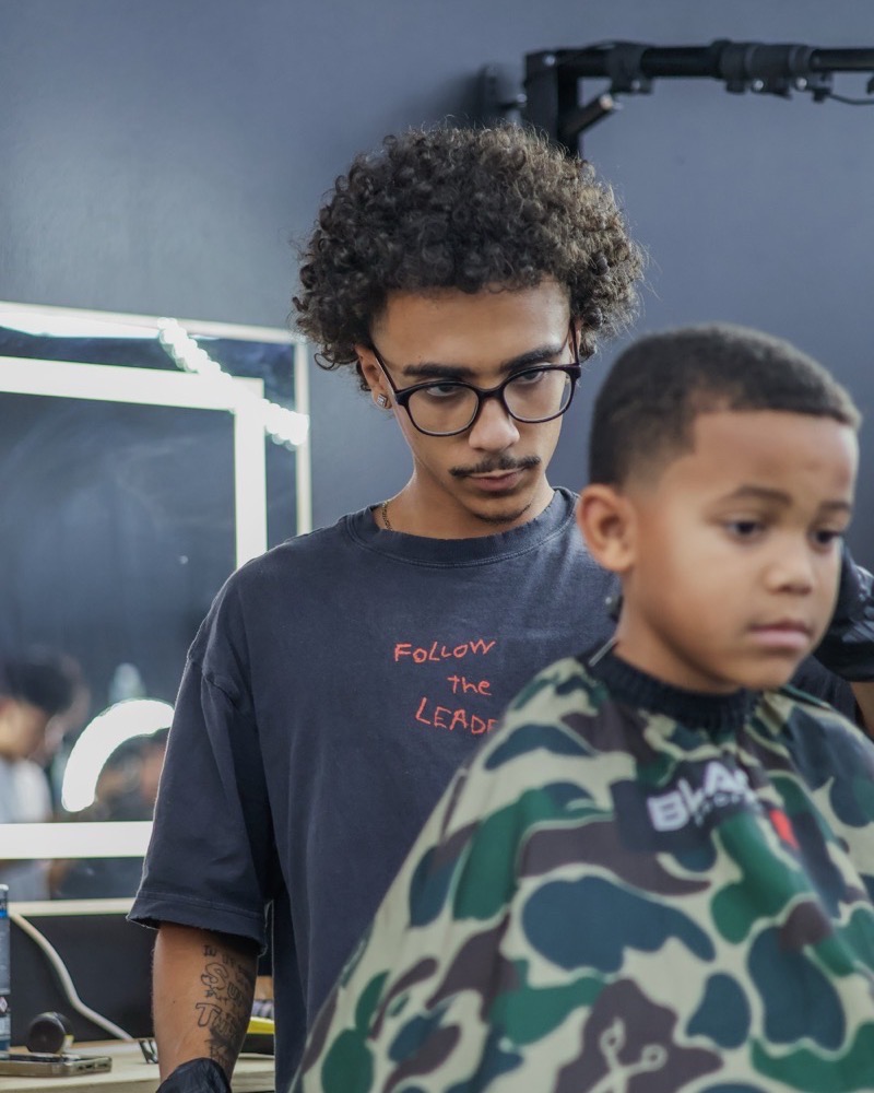 Titus Cutz cutting a client at Plugged N Empire
